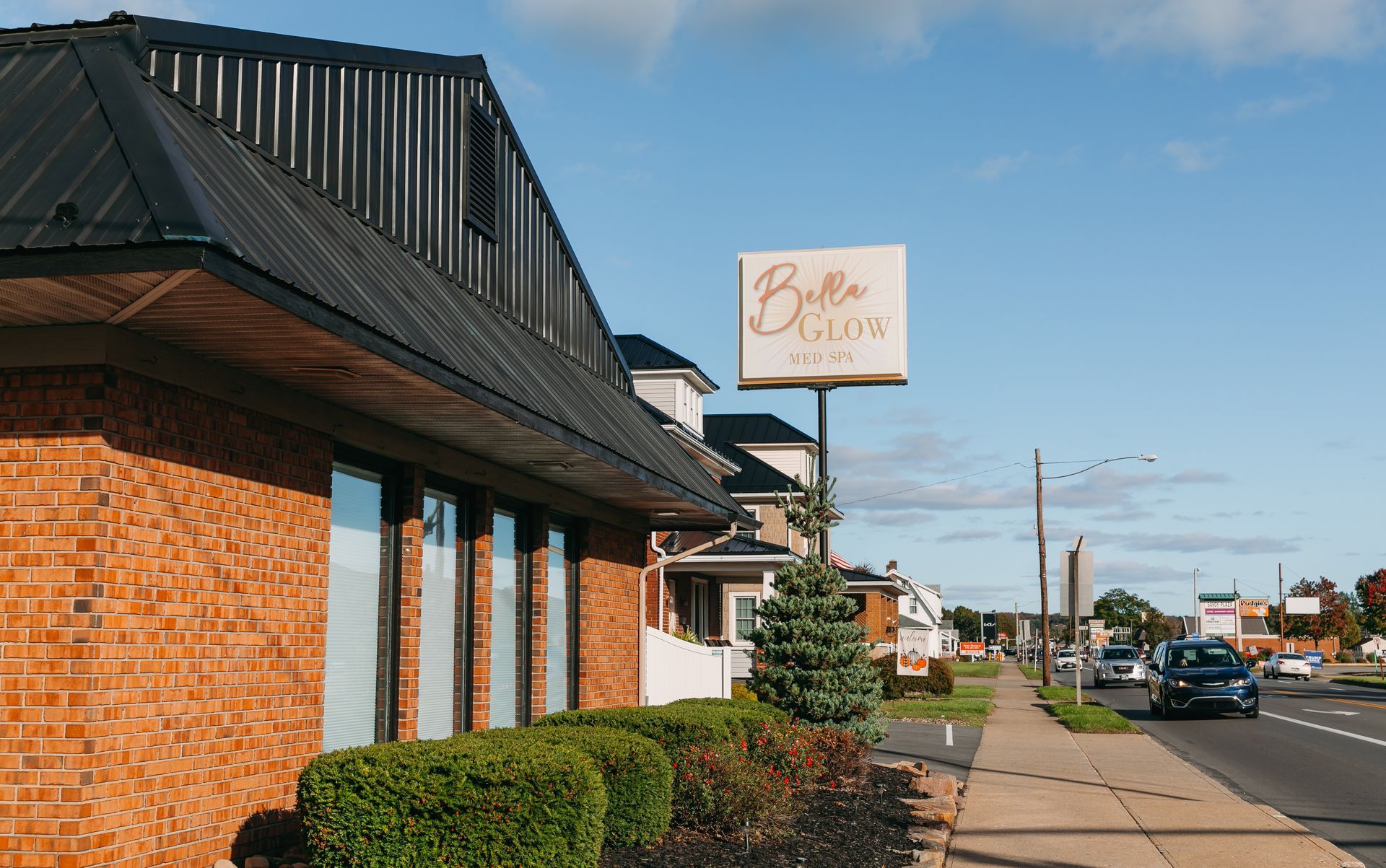 A brick building with a sign on the side of the road.