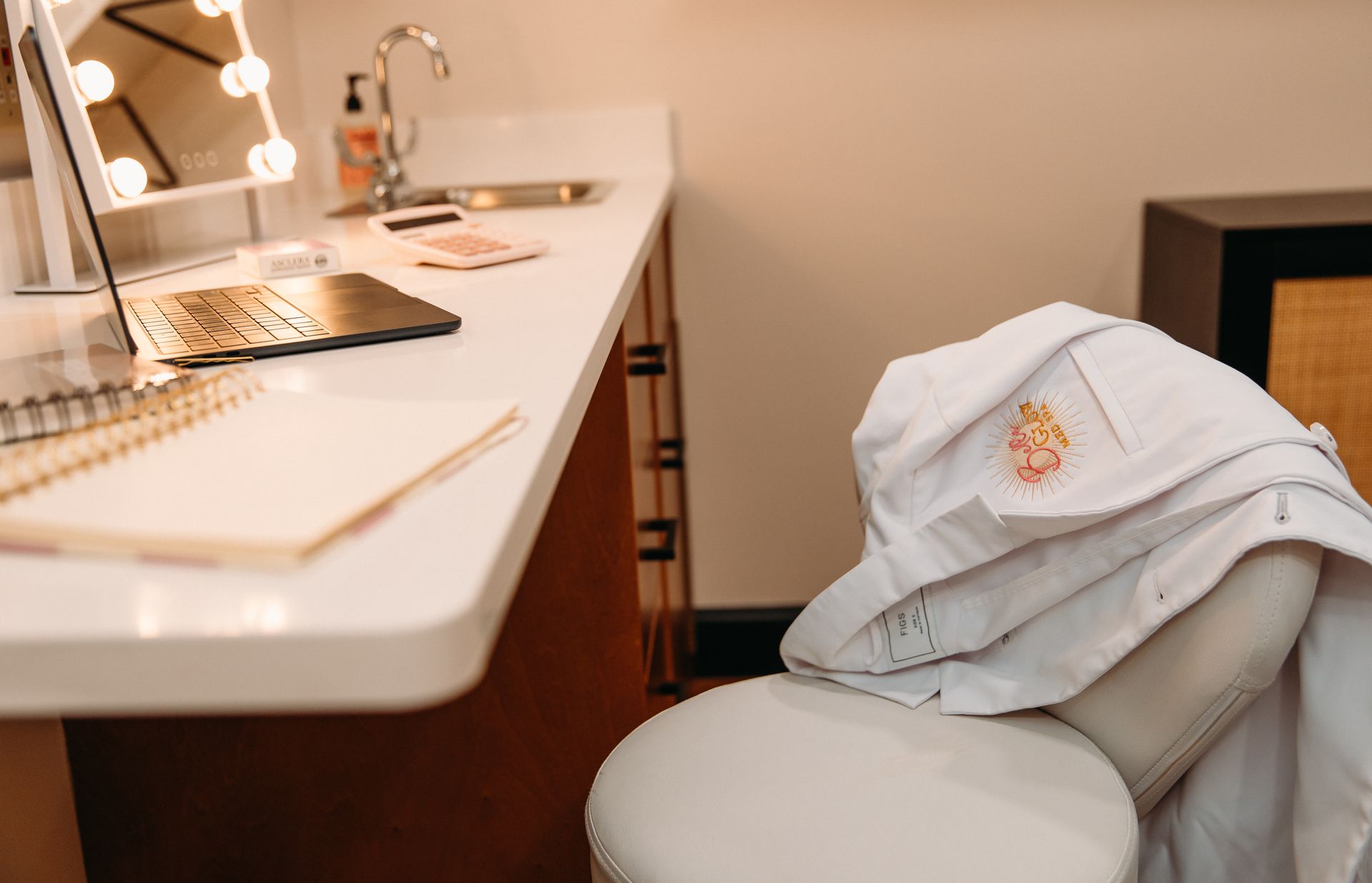 A white robe is sitting on a chair in front of a vanity.