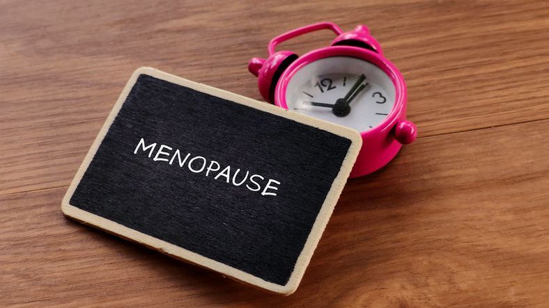 A man and a woman are standing back to back with their arms crossed.