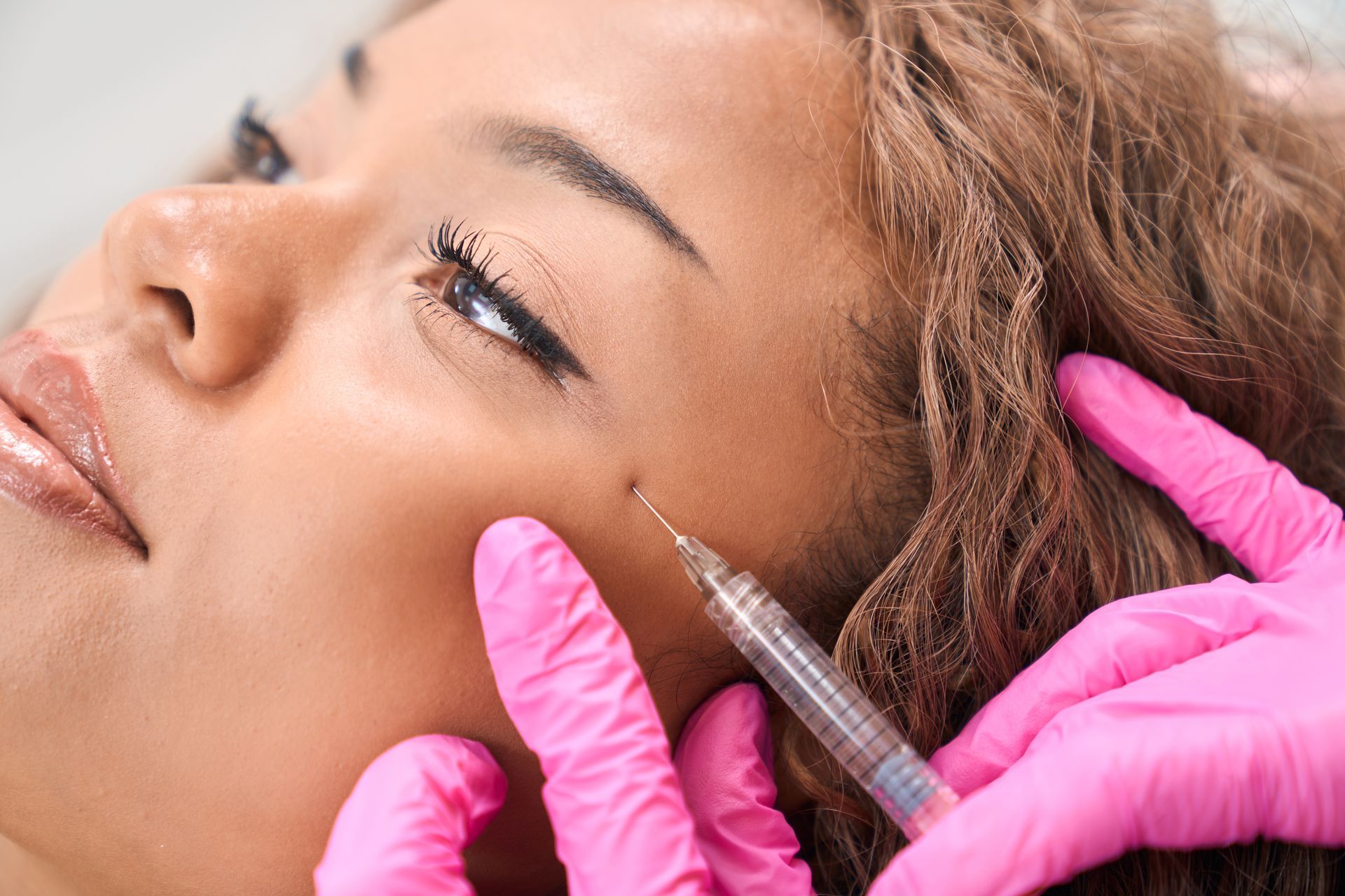 A woman is getting a botox injection in her face.