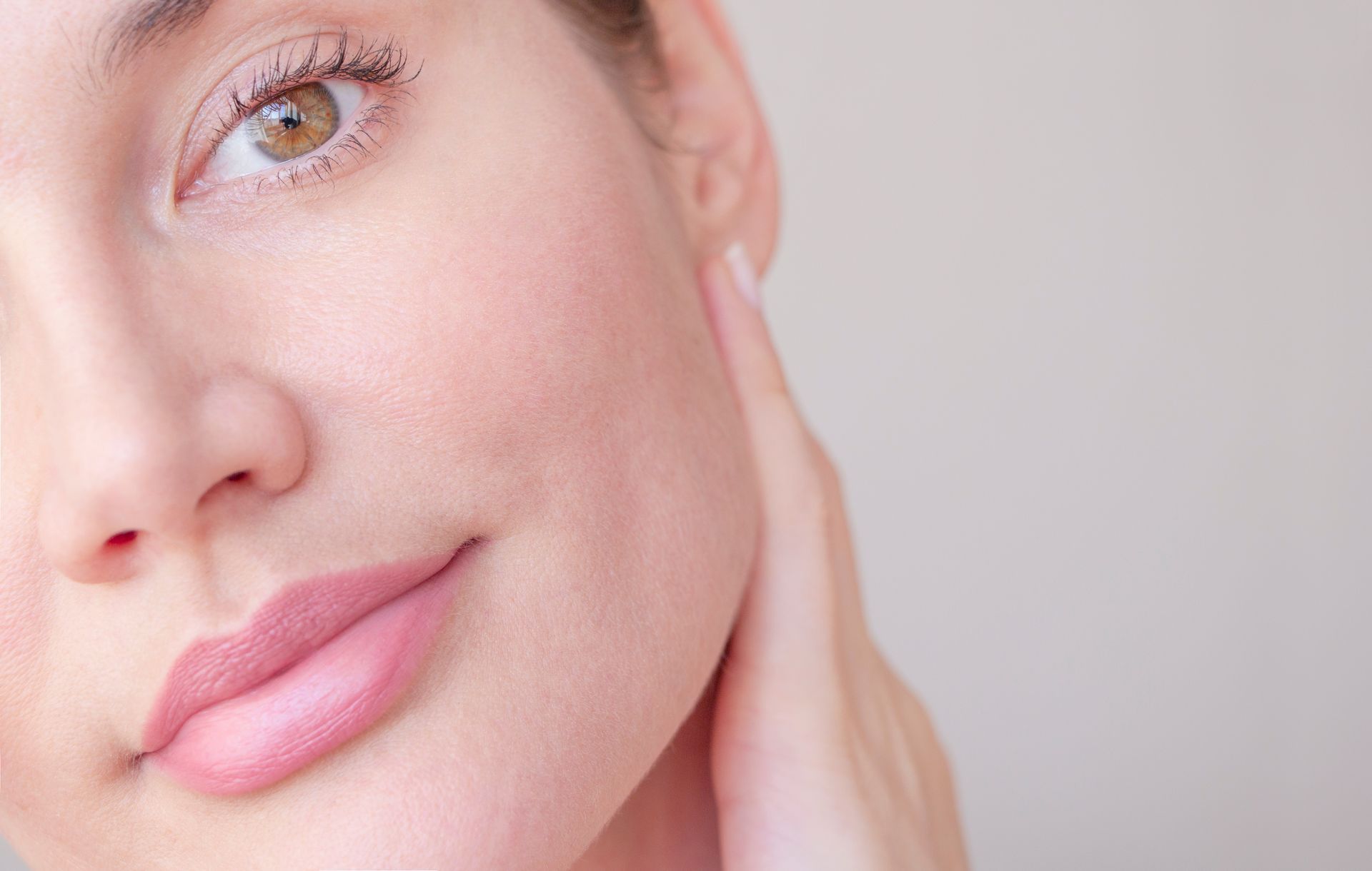 A close up of a woman 's face with a hand on her chin.