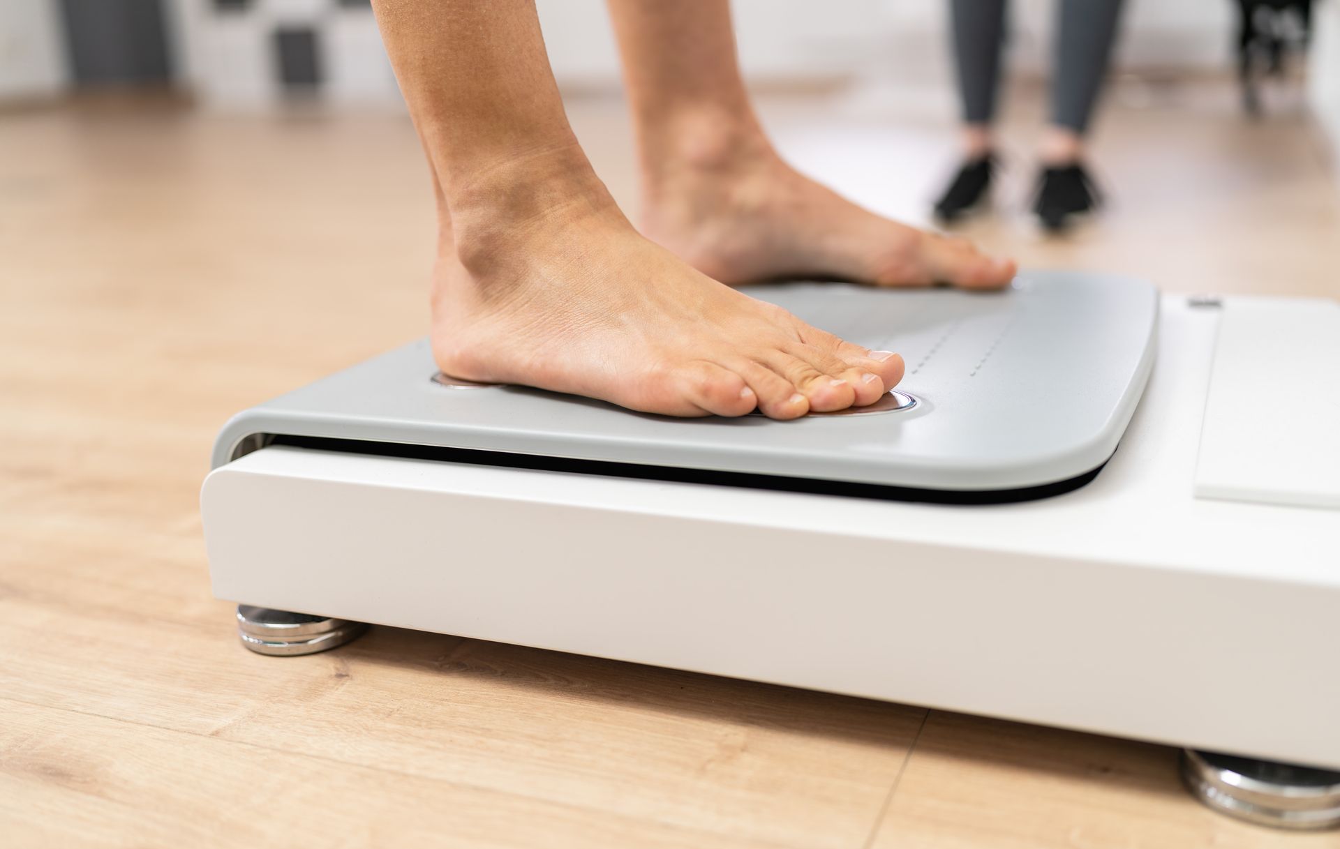 A person is standing on a scale with their feet on it.