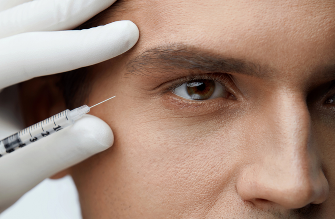 Ein Mann bekommt eine Botox-Injektion in die Stirn.