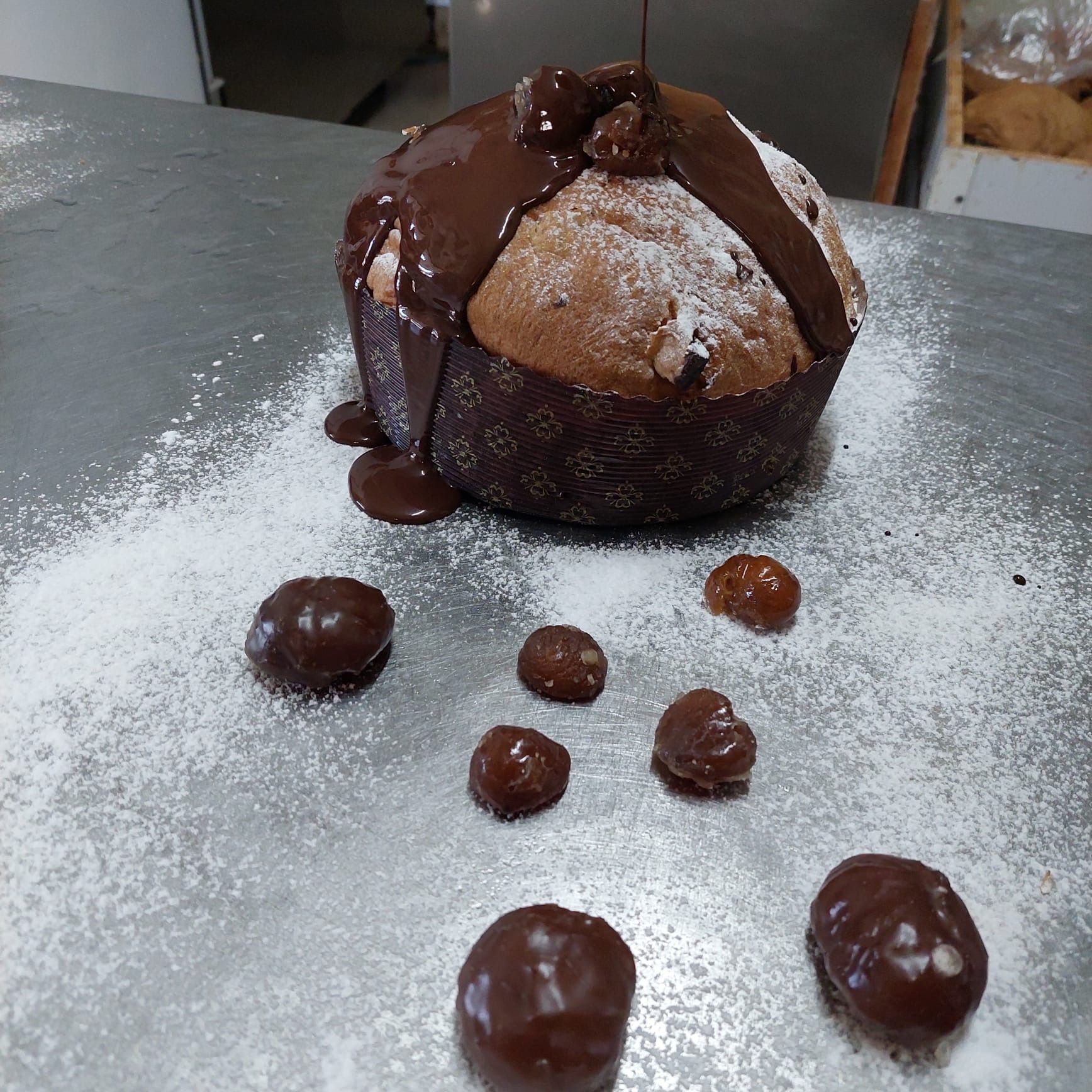 Torta con salsa al cioccolato e castagne su una superficie in polvere.