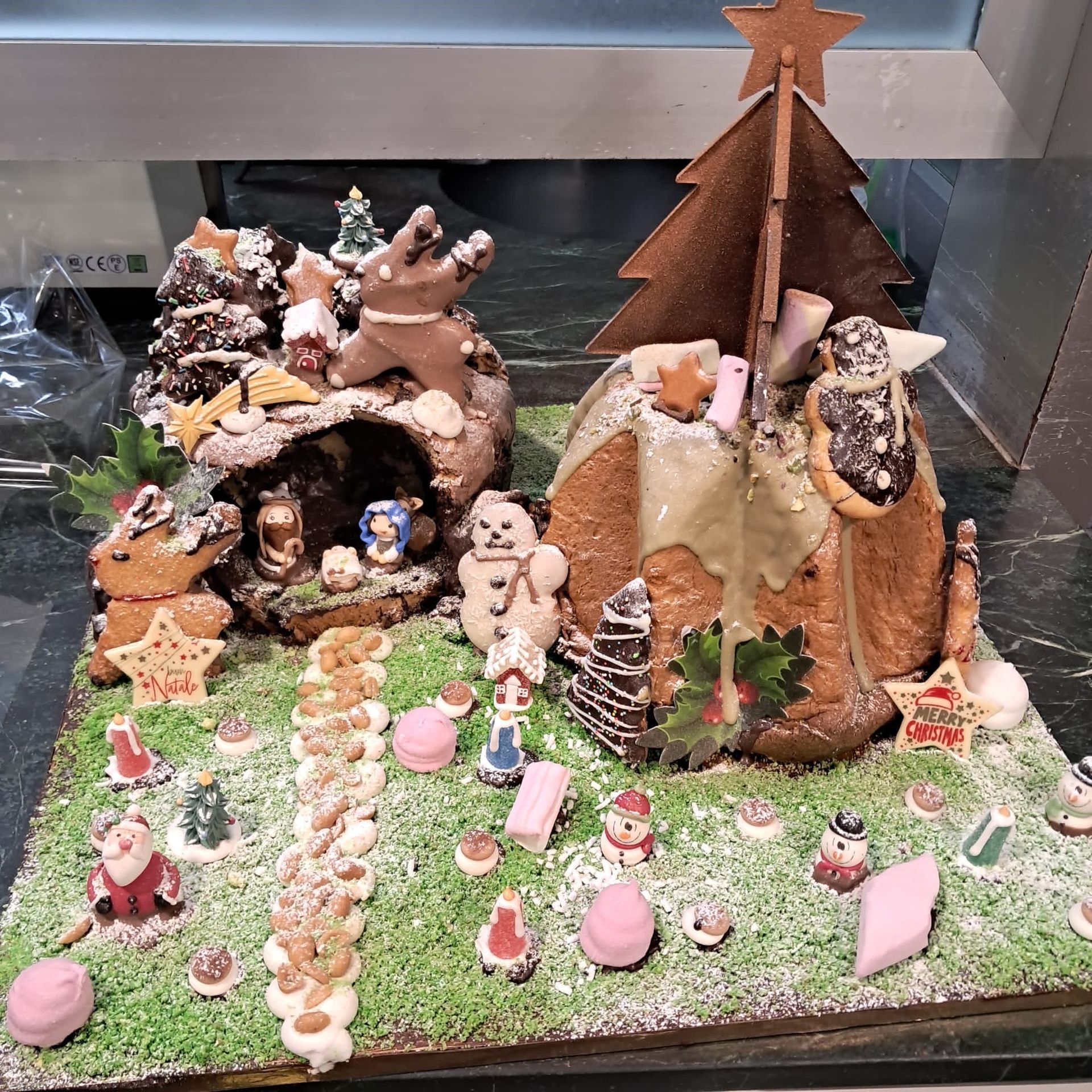 Scena natalizia di pan di zenzero con figure e albero, ricoperta di 