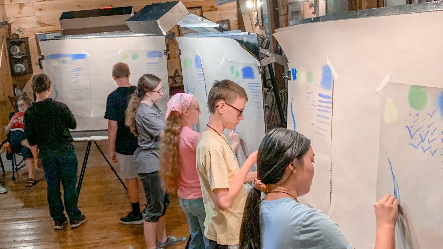 A group of children are standing in front of a whiteboard.