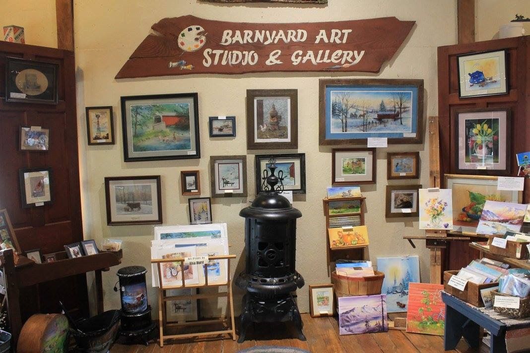 A barnyard art studio and gallery with paintings on the wall