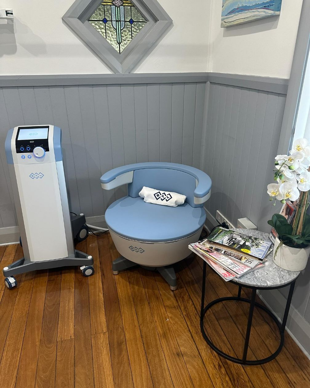 A Chair is Sitting in a Room Next to a Table and a Machine — Renew Laser Clinic in Taree, NSW
