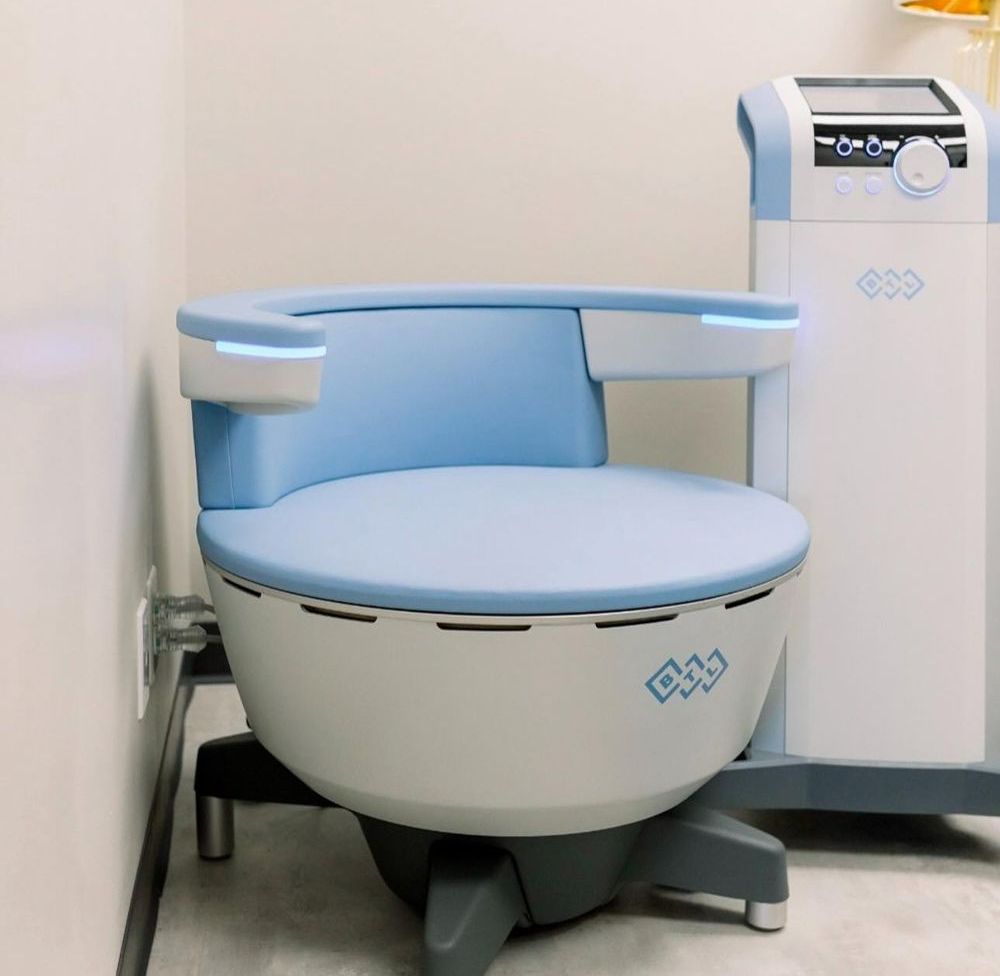A White Chair With a Blue Seat Sits Next to a Machine — Renew Laser Clinic in Taree, NSW