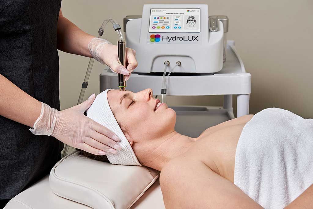 A Woman is Laying on a Bed Getting a Facial Treatment — Renew Laser Clinic in Taree, NSW