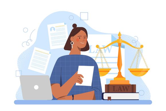 A woman is sitting at a desk with a laptop and a scale of justice.