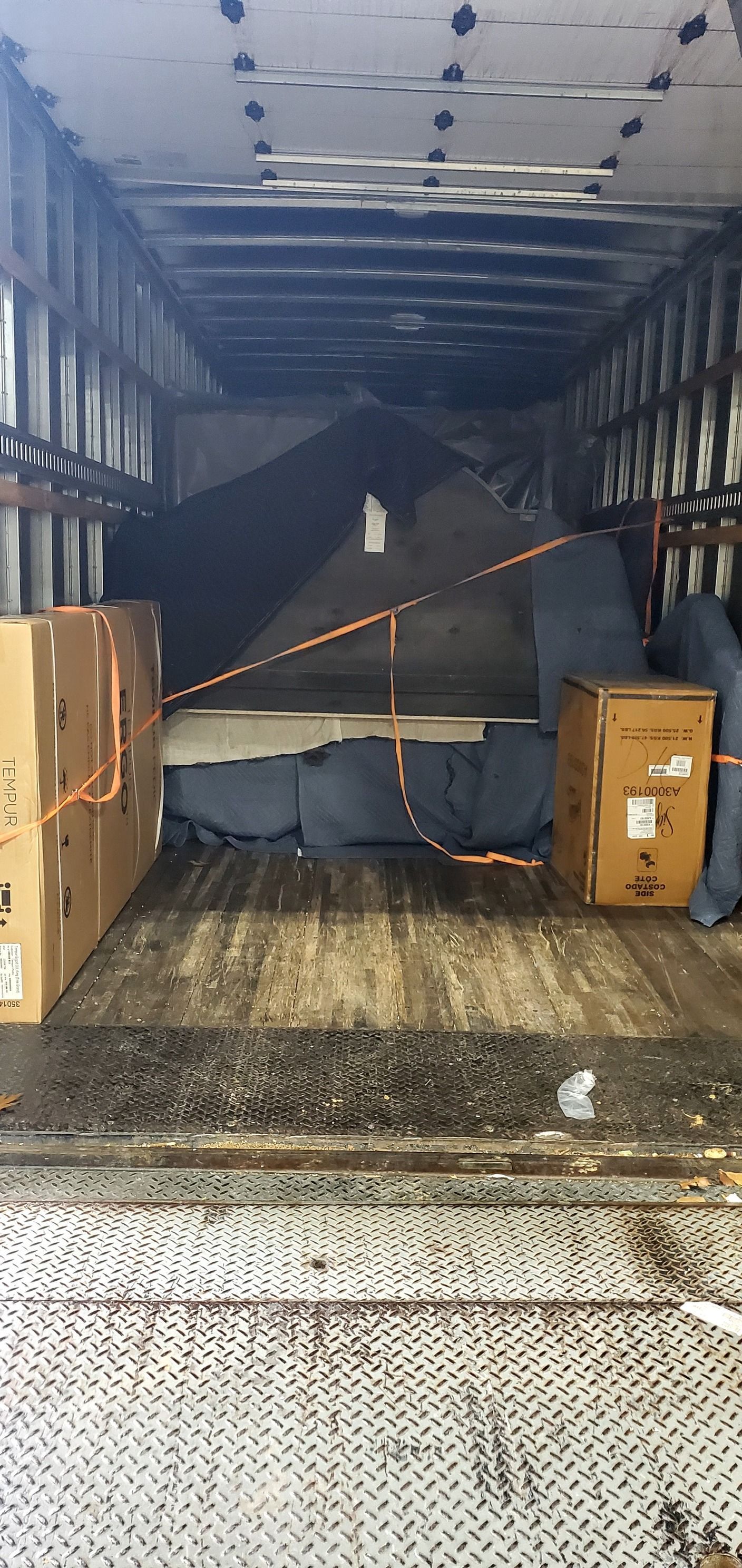 The back of a moving truck filled with boxes and furniture.