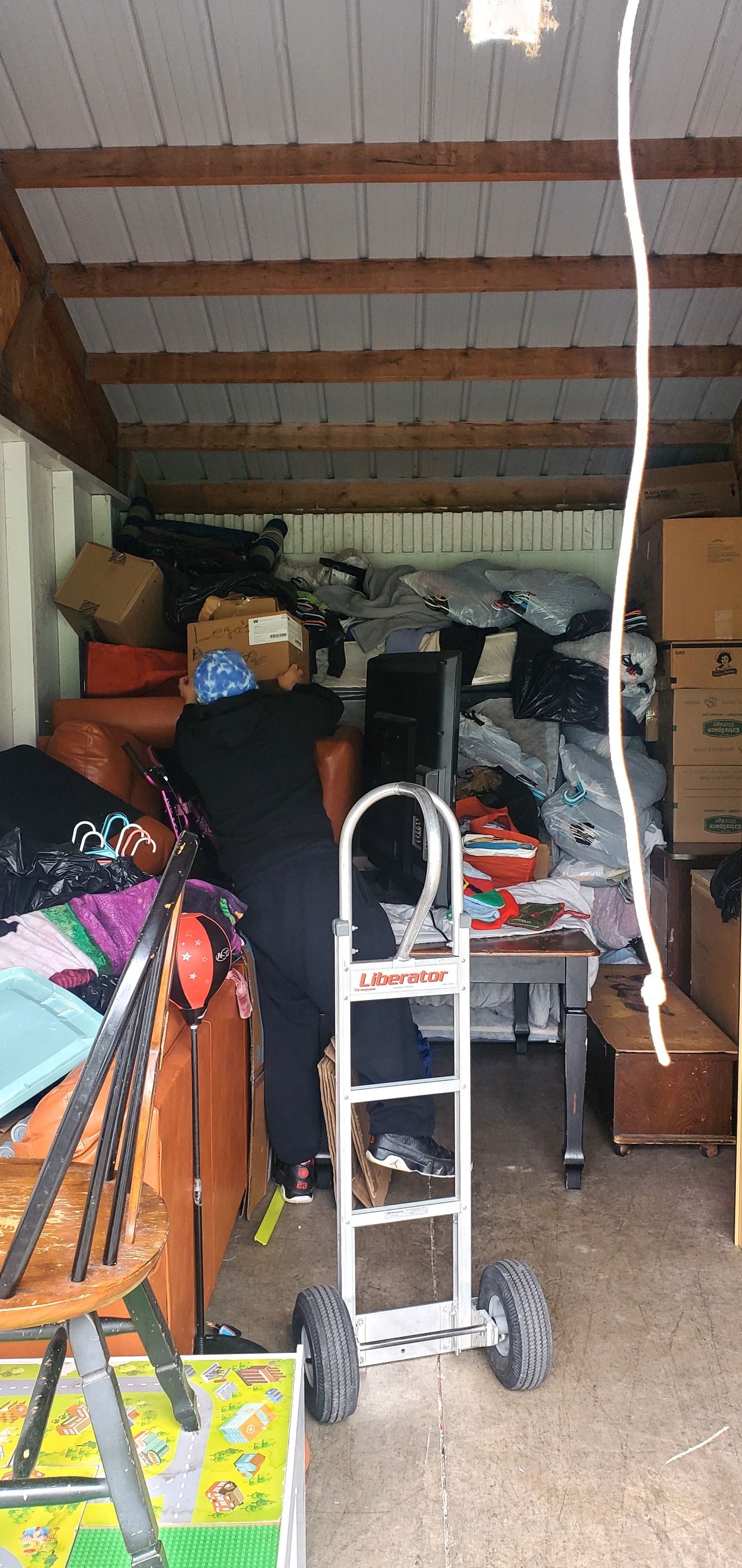 A room filled with lots of boxes and a hand truck.