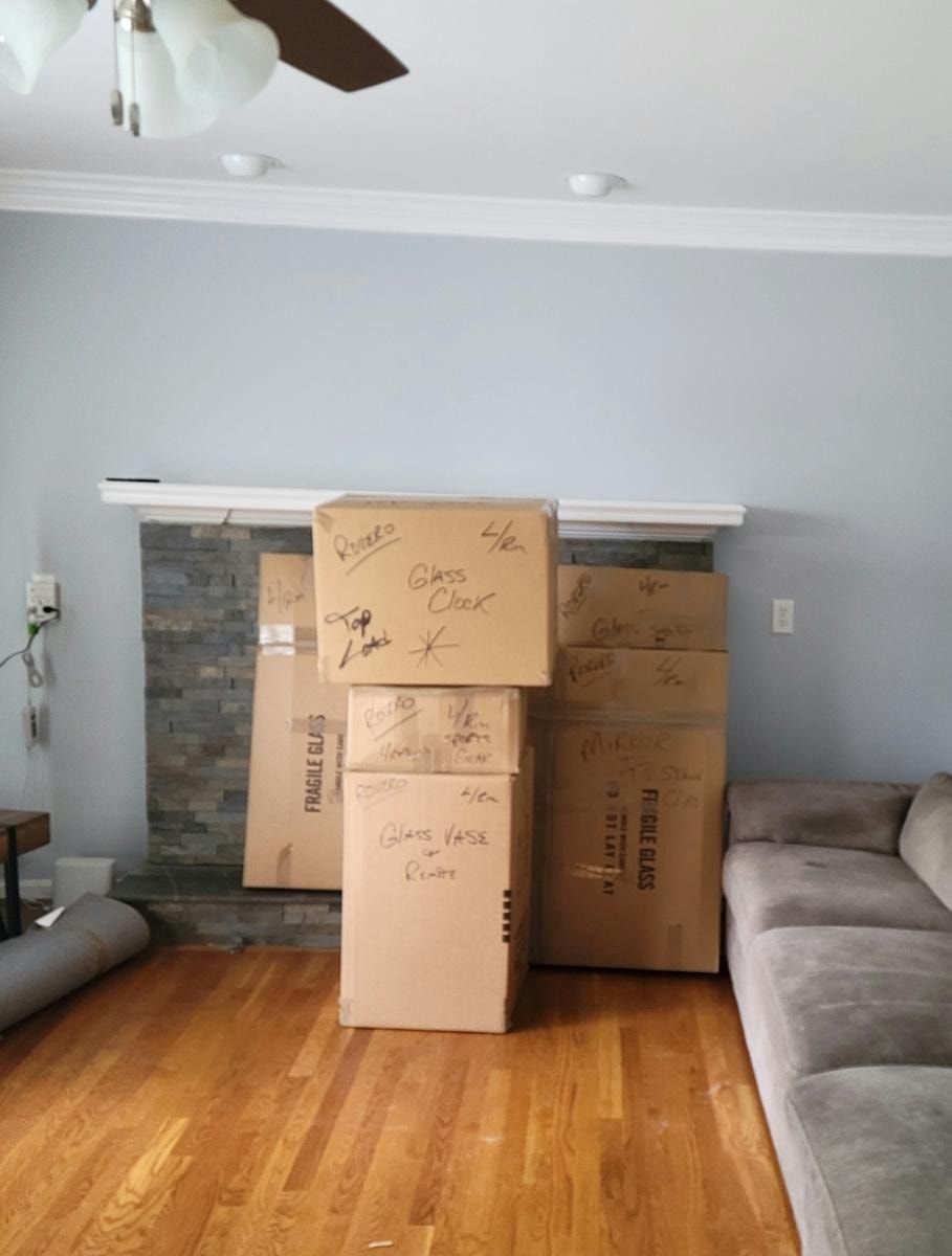 A living room filled with cardboard boxes and a couch
