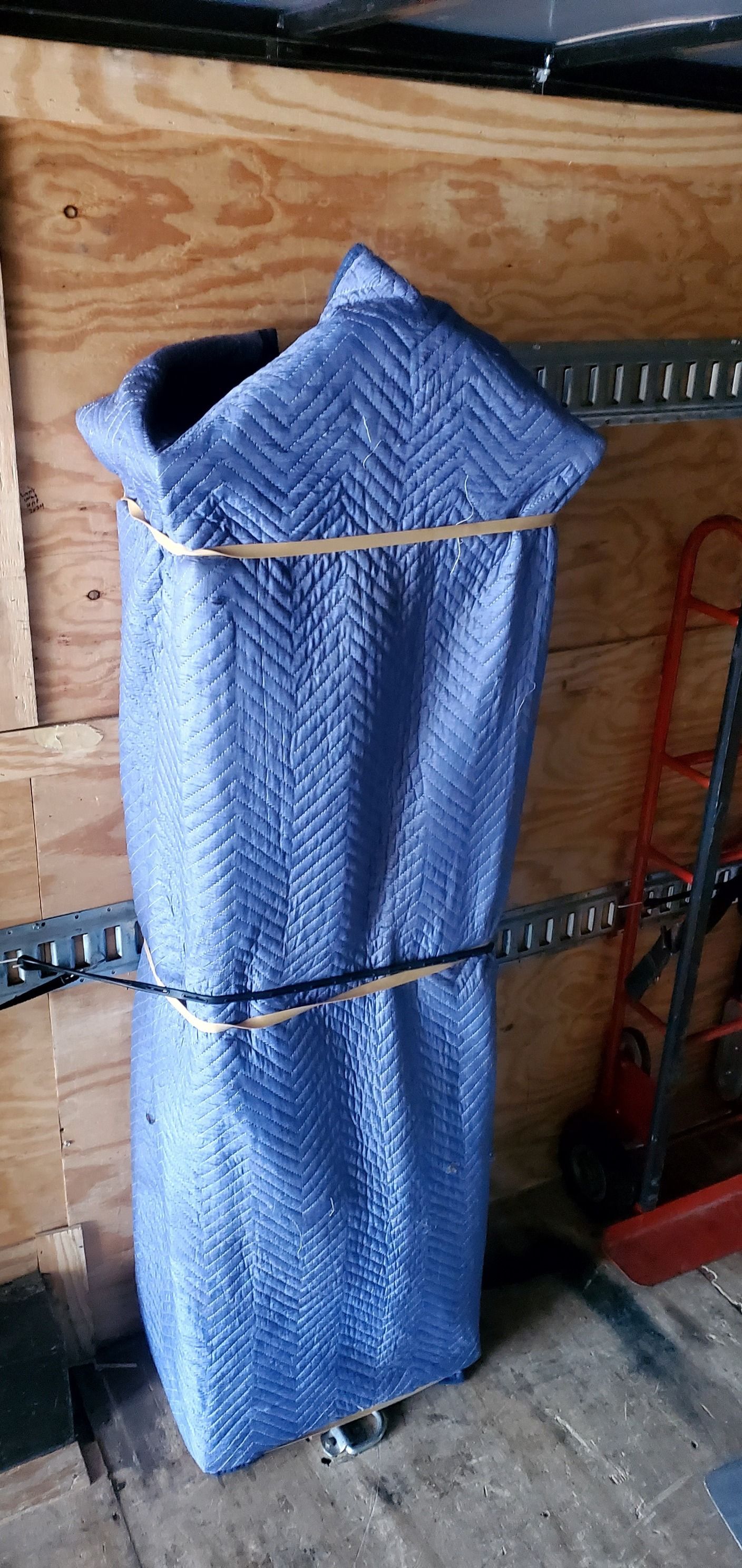 A blue bag is wrapped in a blue cloth and tied with rubber bands.