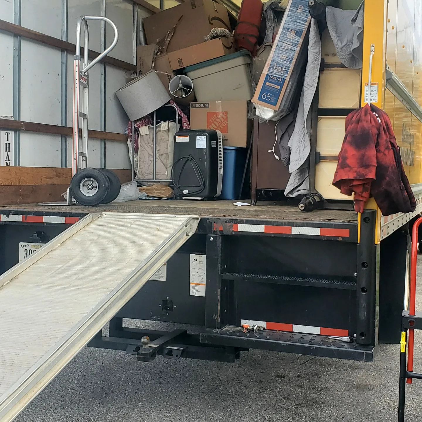 A moving truck is loaded with boxes and a speaker