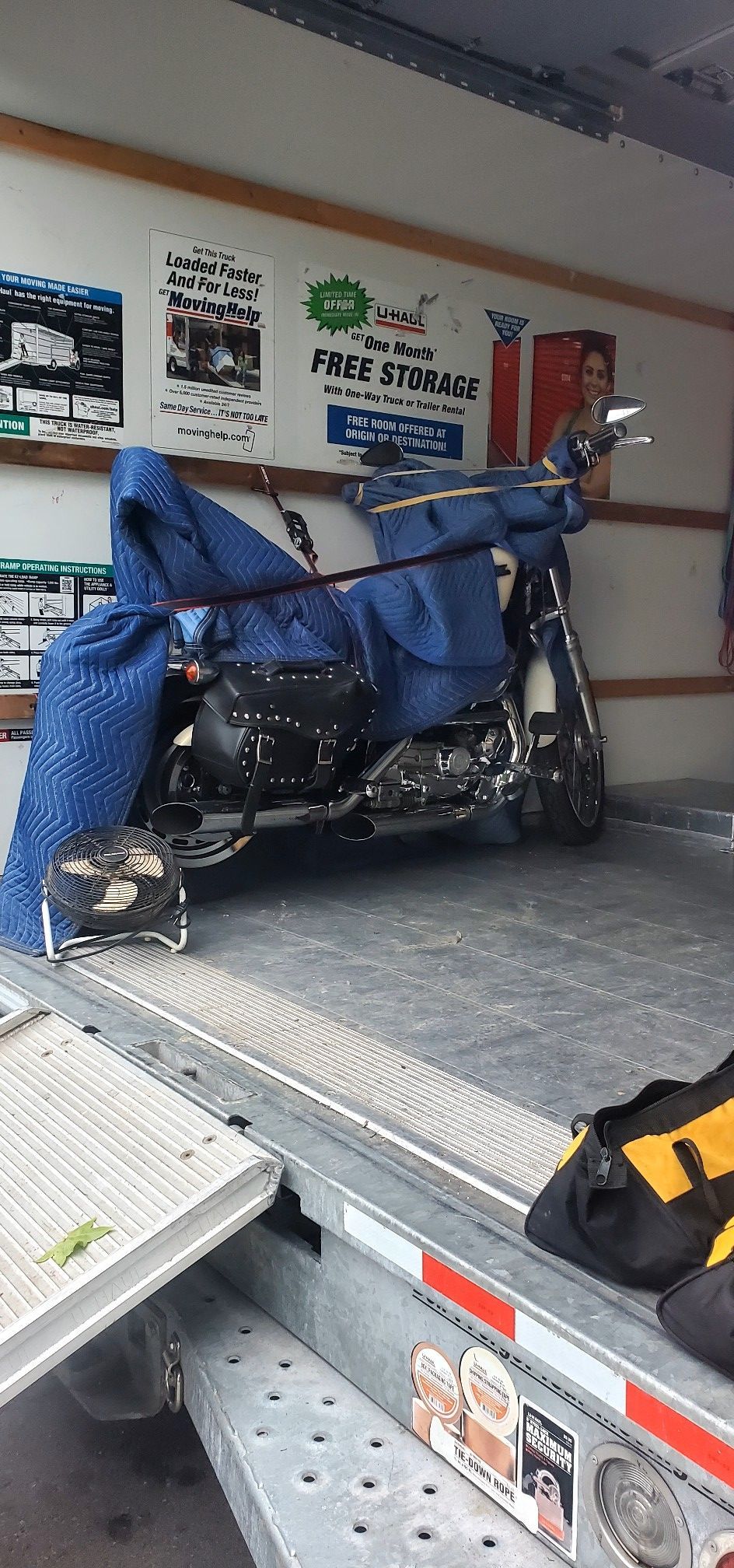 A motorcycle is sitting on the back of a trailer.