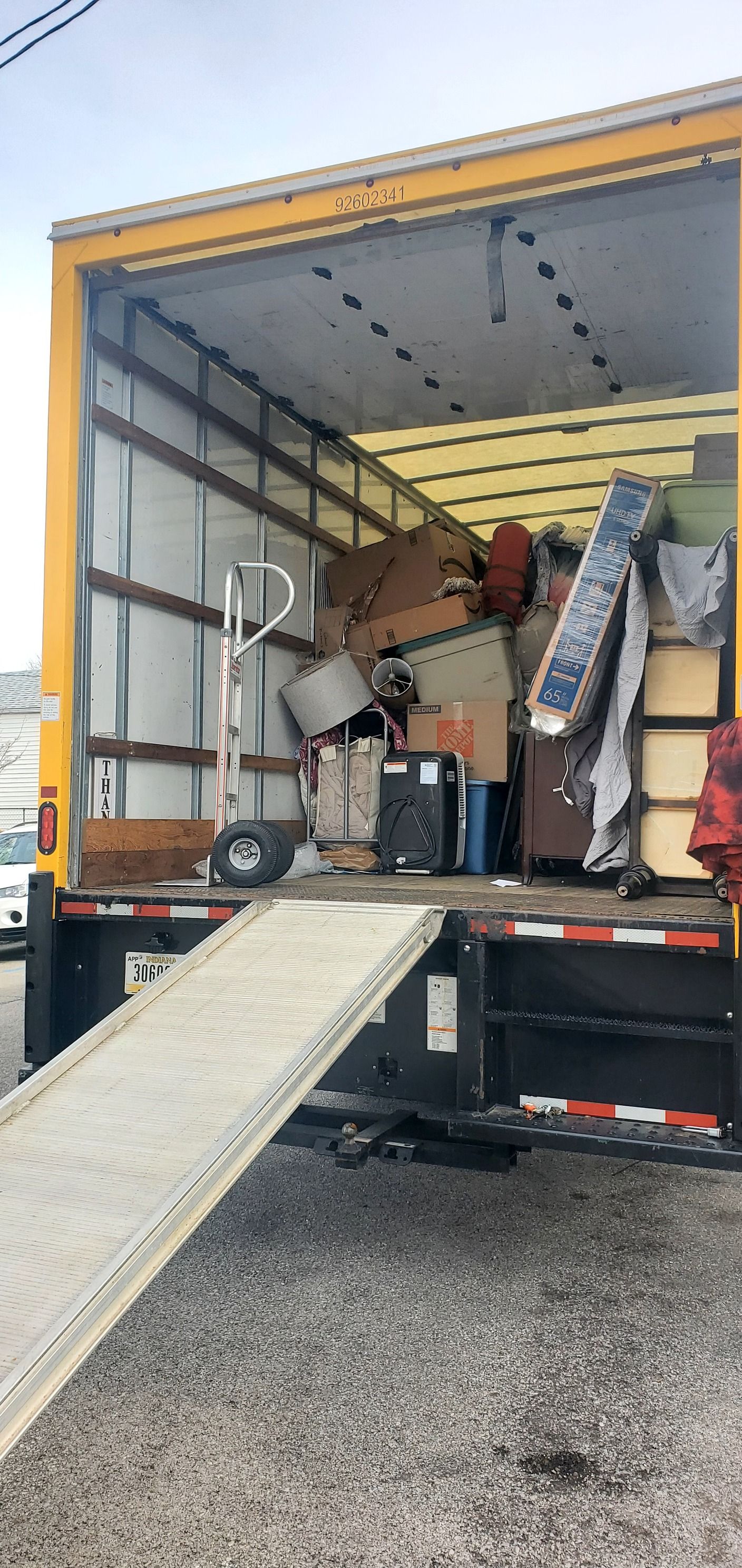 The back of a moving truck is filled with lots of furniture.