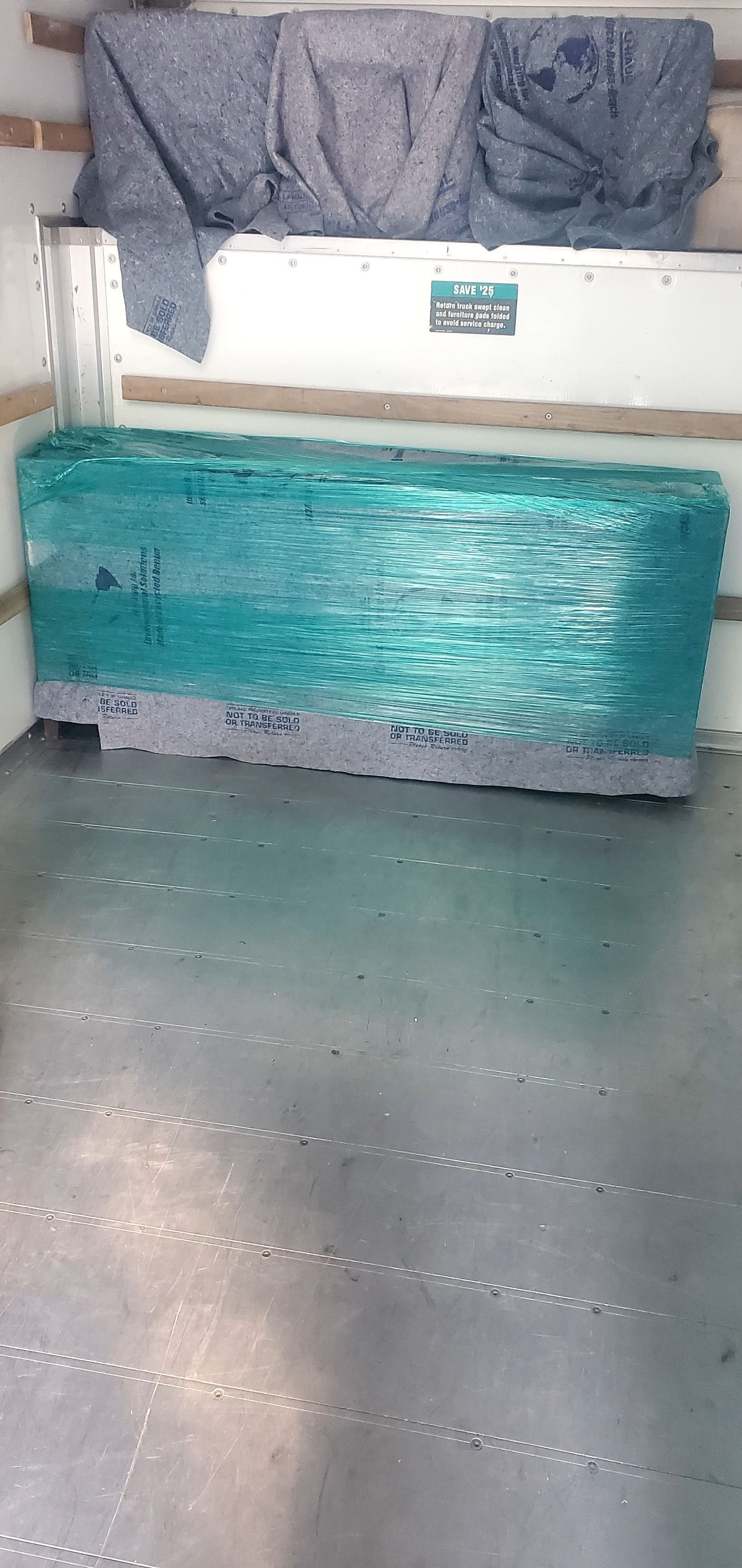 A large piece of ice is wrapped in plastic in a truck.