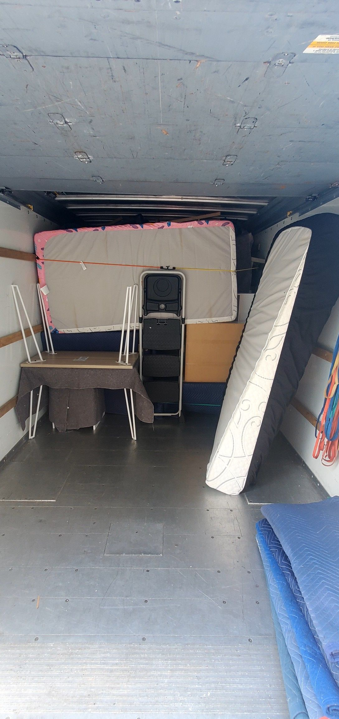 A van filled with furniture and a mattress.