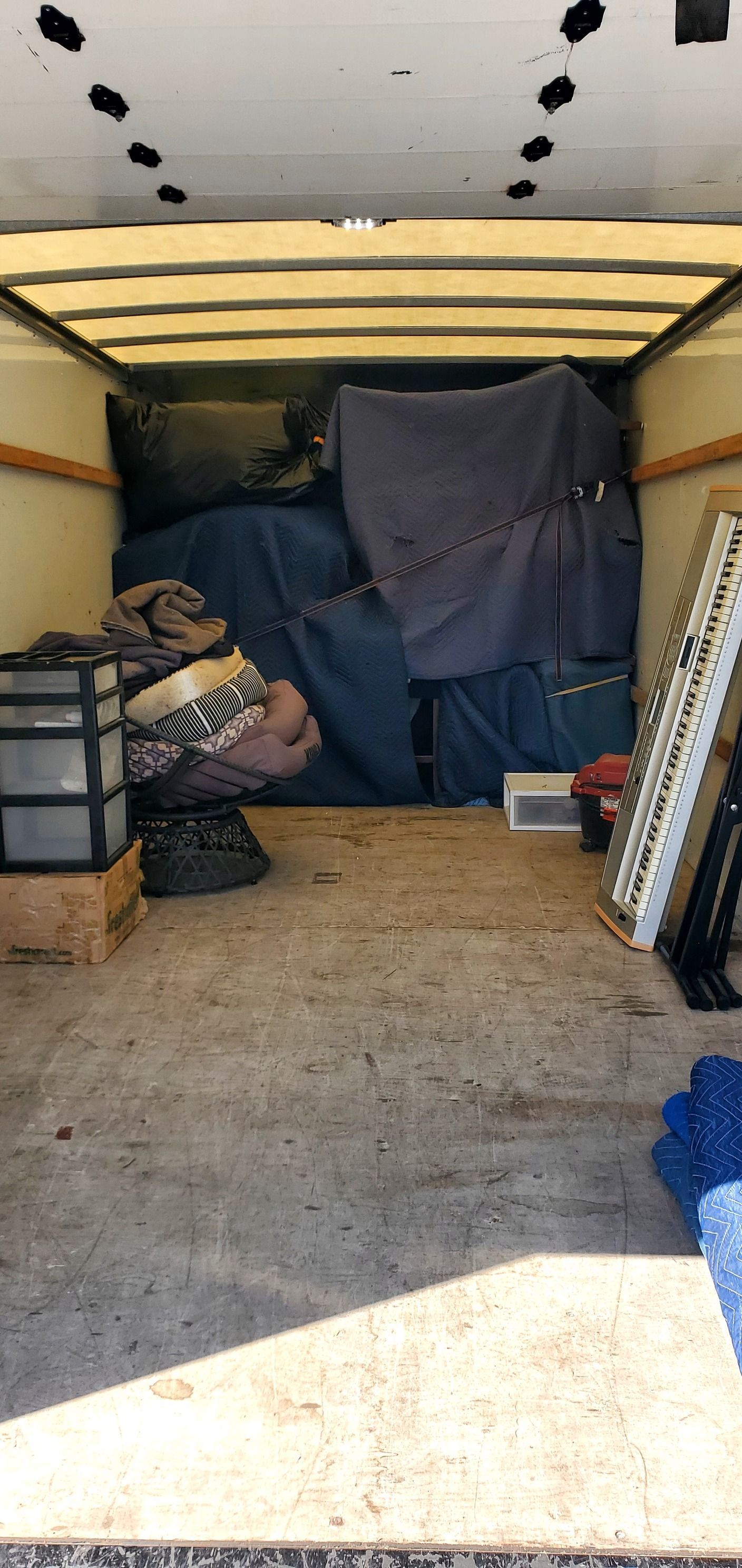 The inside of a moving truck filled with furniture and boxes.