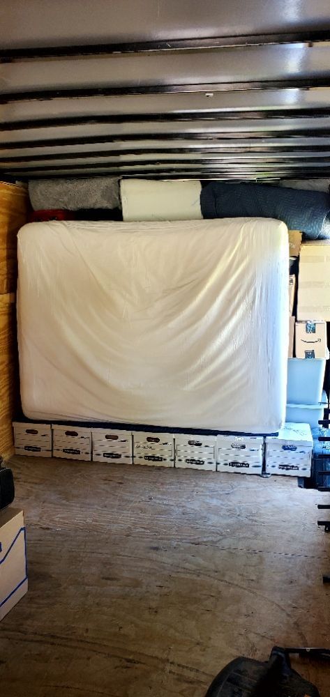 A large white mattress is sitting in the middle of a room.
