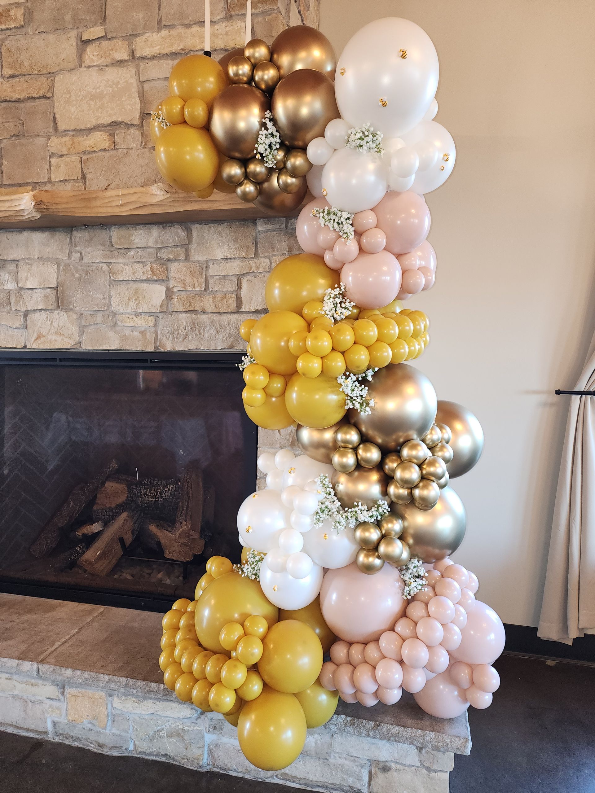 A bunch of balloons are sitting on top of a fireplace.