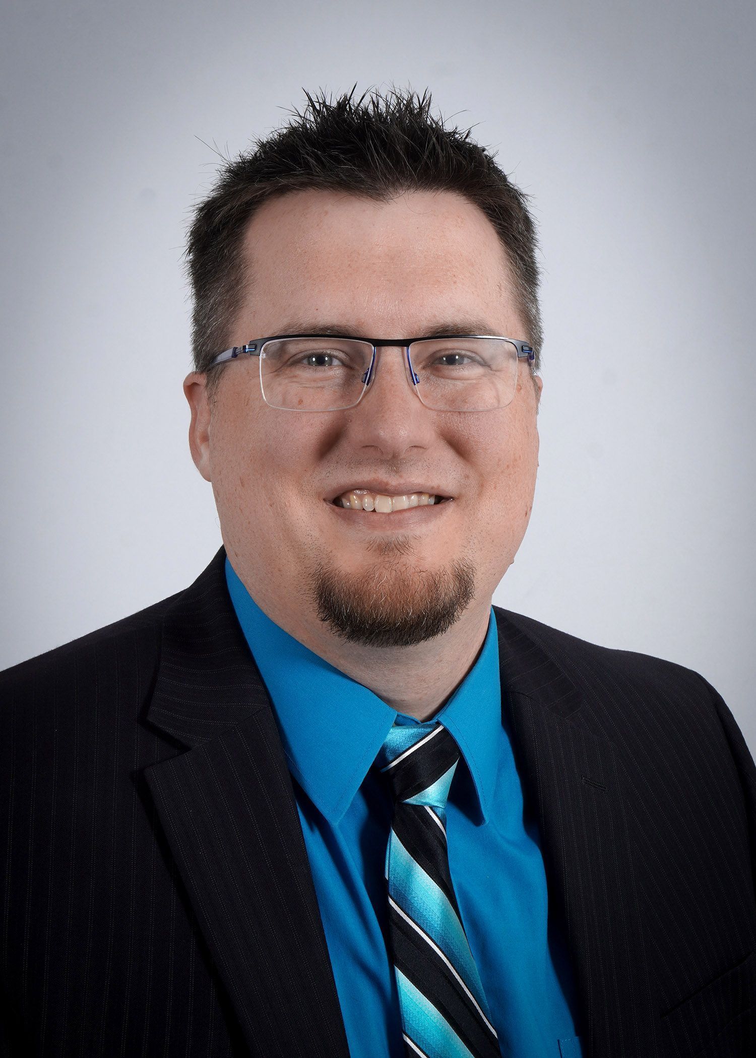 A man in a suit and tie is smiling for the camera.