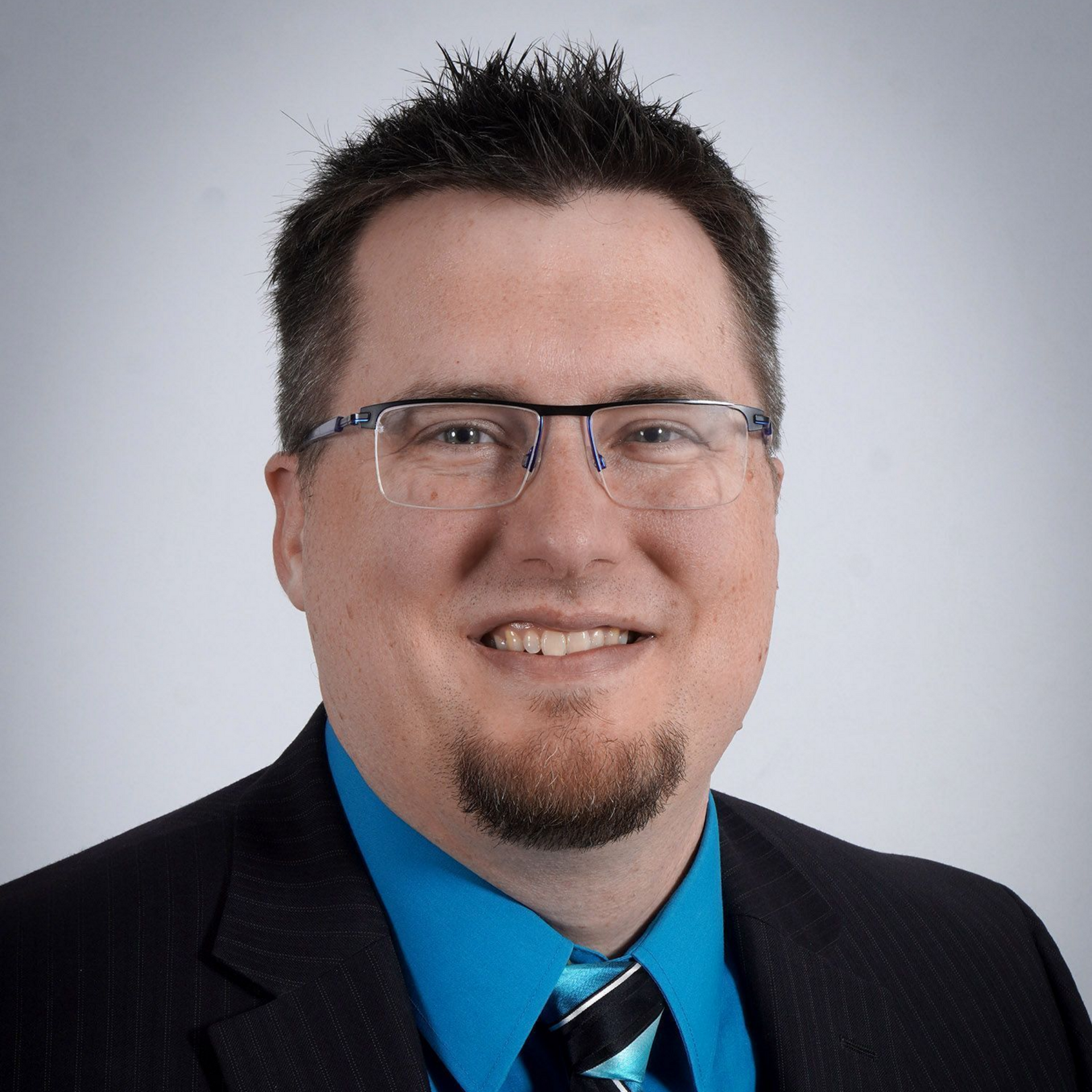 A man in a suit and tie is smiling for the camera.
