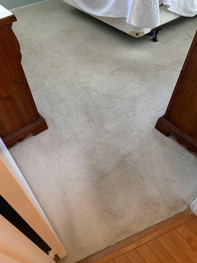 A bedroom with a bed , nightstands , and a carpeted floor.