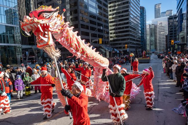 A group of people are holding a dragon in a parade.