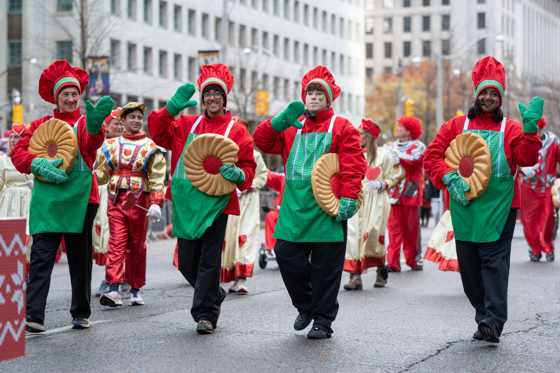 A group of people in blue bunny costumes are holding carrots in a parade.