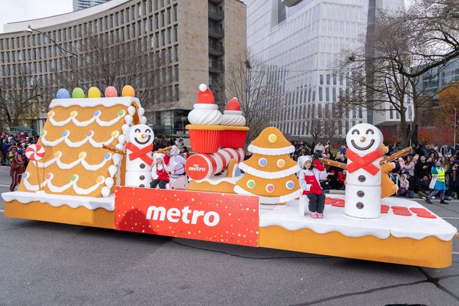 A christmas parade with a float that looks like a gingerbread house.