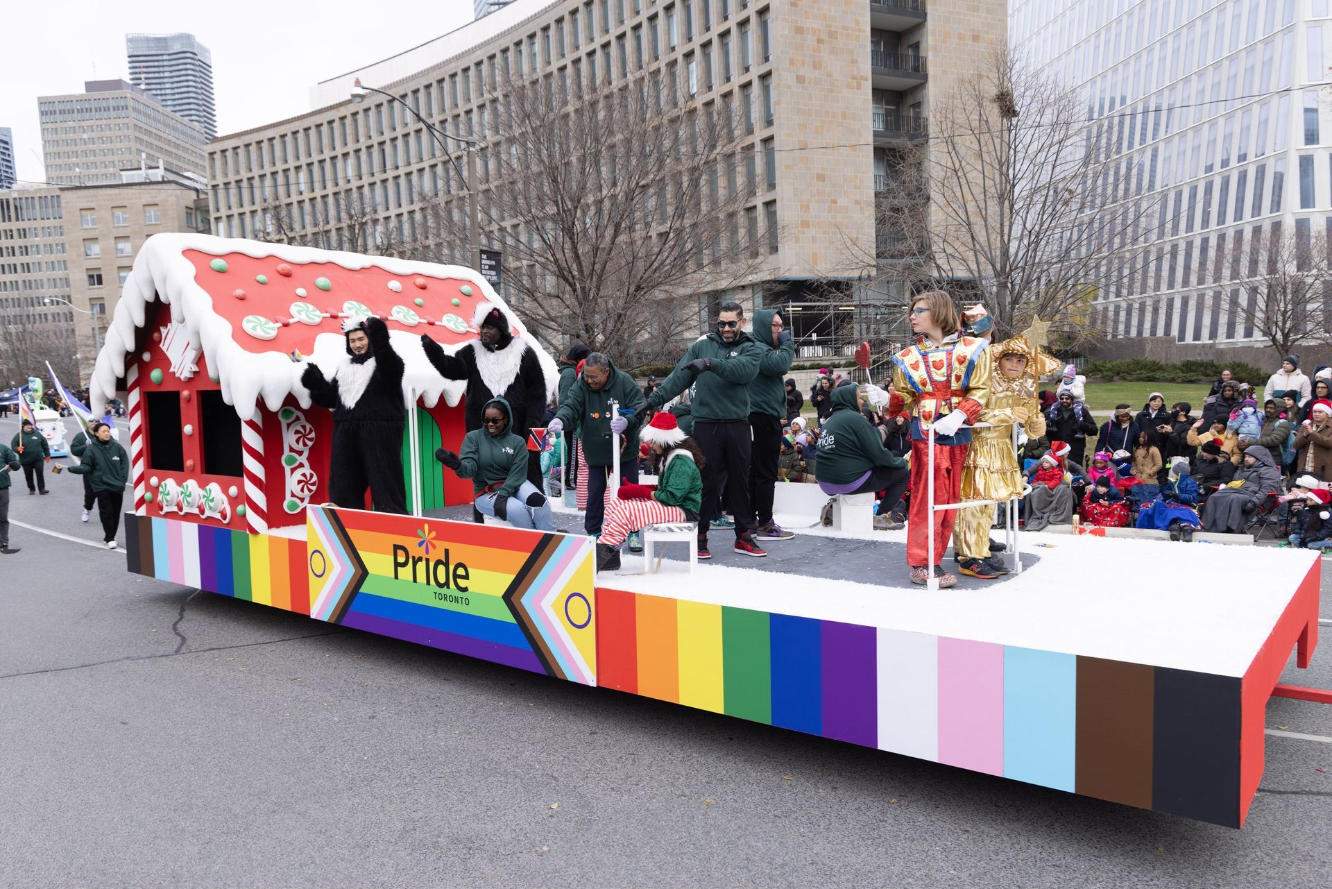 A christmas parade with a gingerbread house on a float.