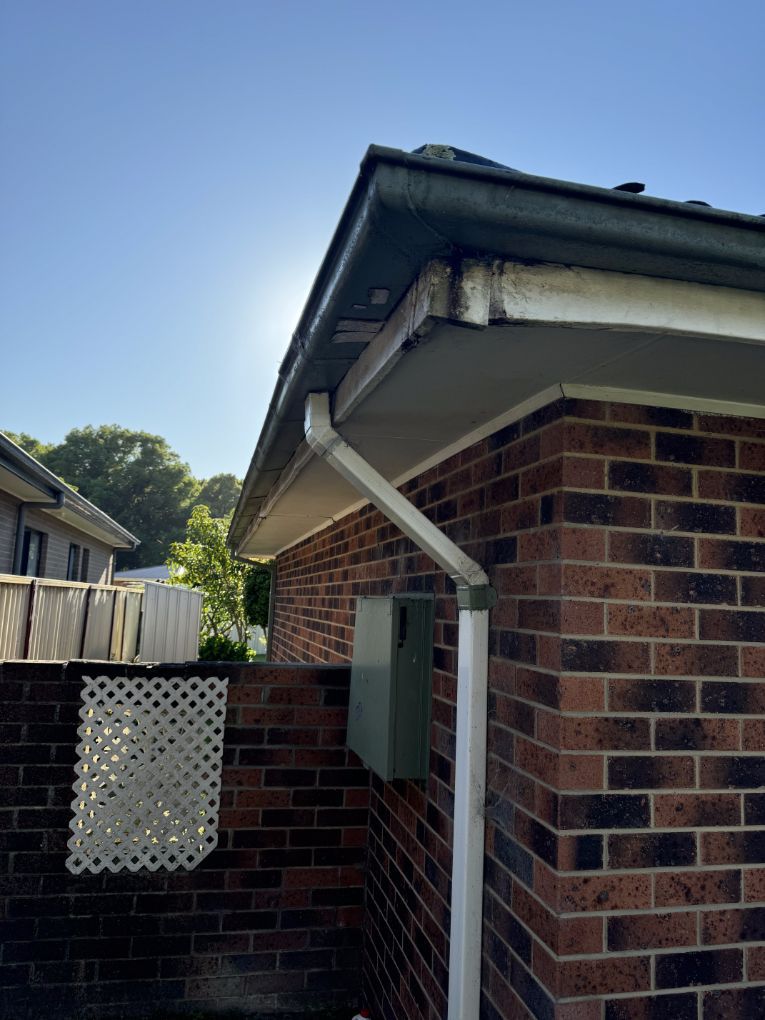 A Brick House With a White Gutter on the Side of It — Platinum Pride Roofing In Terrigal, NSW