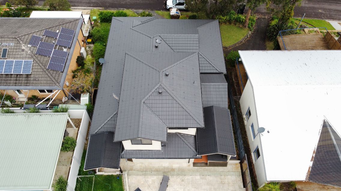 An Aerial View of a House With a Roof That Has Solar Panels on It — Platinum Pride Roofing In Wyoming, NSW