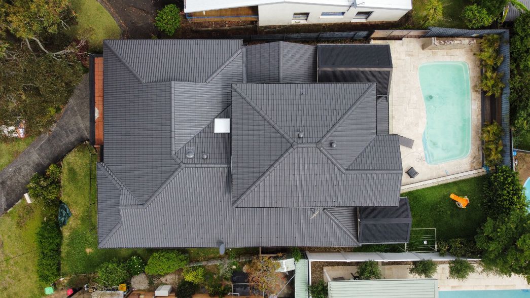An Aerial View of a House With a Black Roof and a Pool — Platinum Pride Roofing In Wyoming, NSW