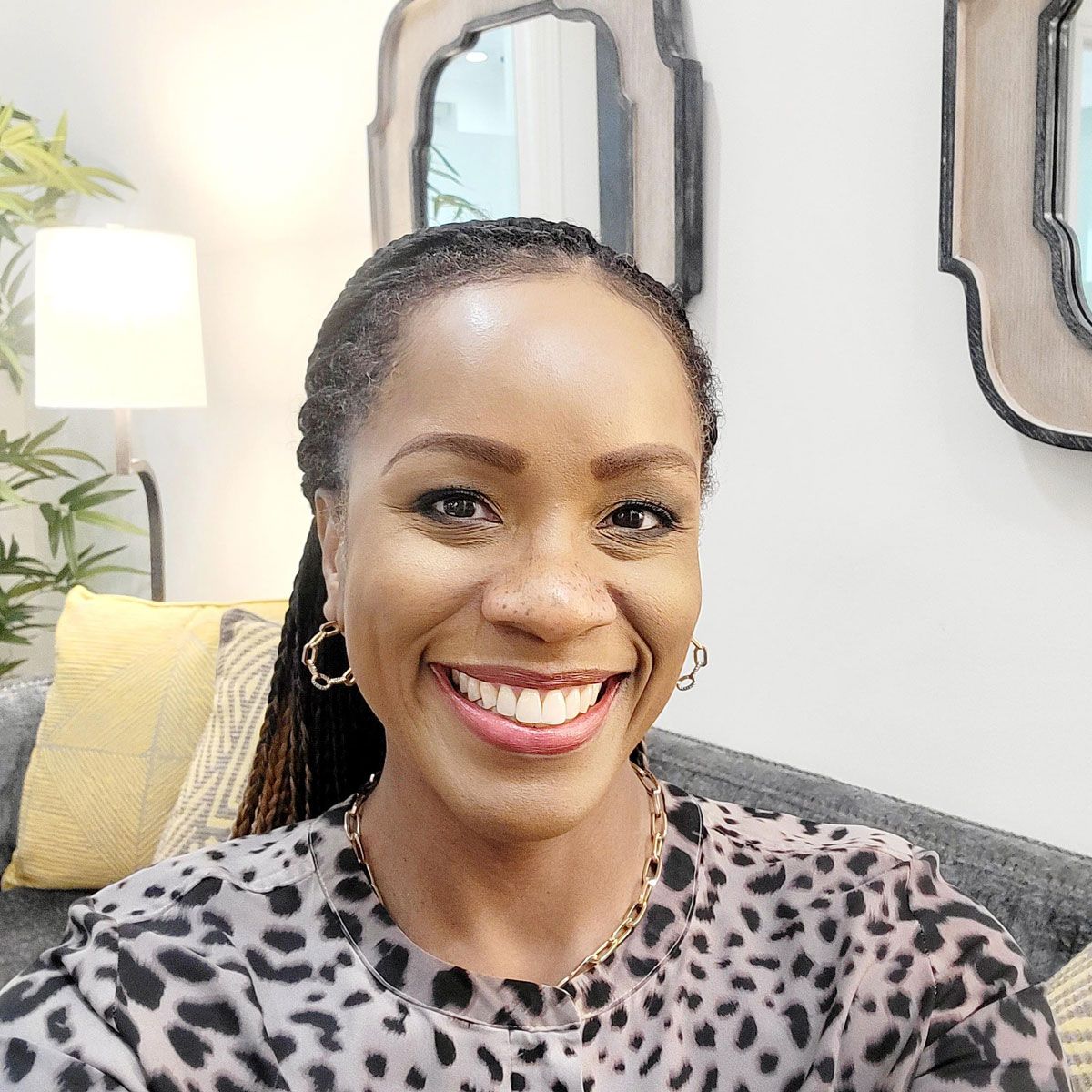 A woman with braids and red lipstick is smiling for the camera. A woman with braids and red lipstick is smiling for the camera.