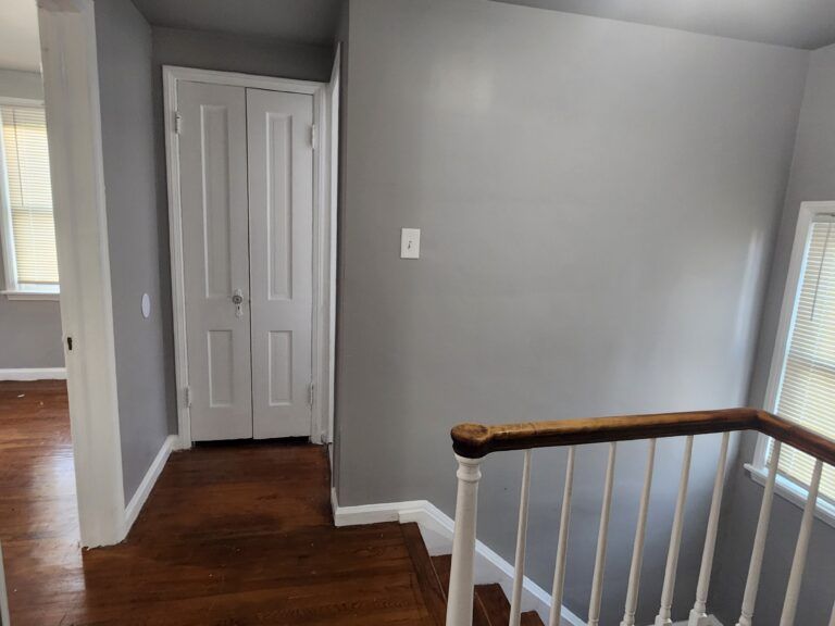 A hallway with stairs leading up to the second floor of a house.