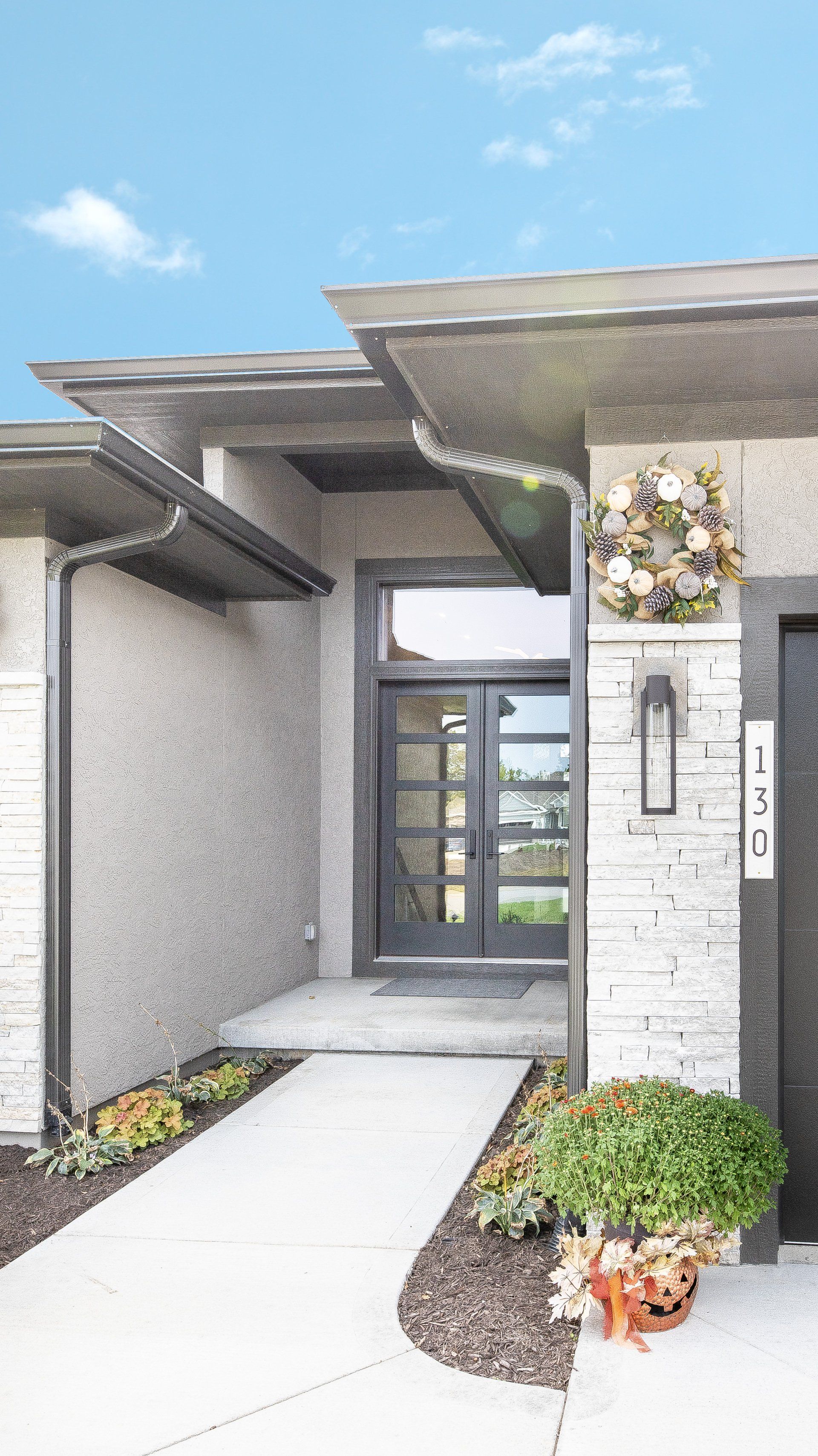 A drawing of a modern house with a walkway leading to the front door.
