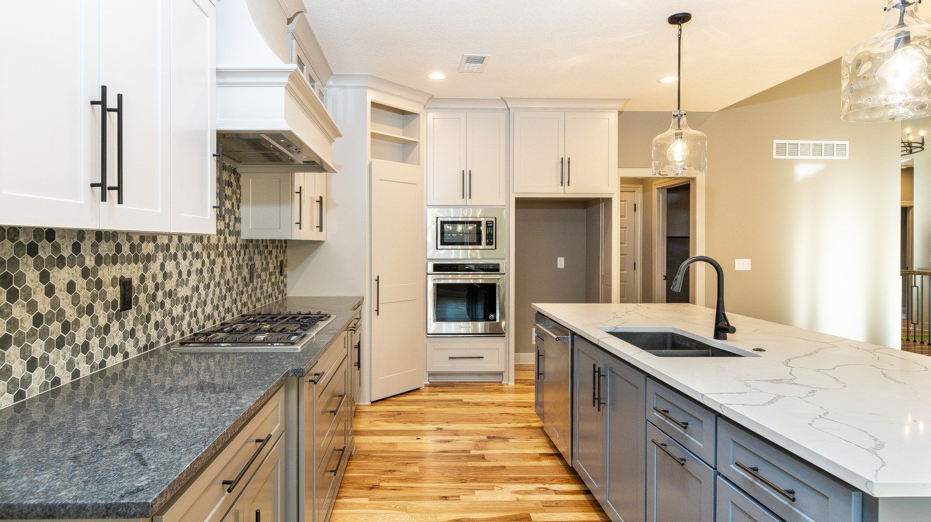 A kitchen with white cabinets , granite counter tops , and stainless steel appliances.