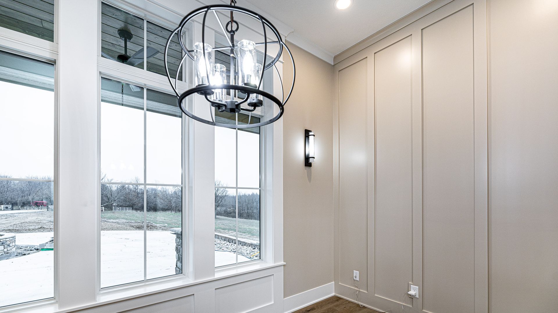A room with a lot of windows and a chandelier hanging from the ceiling.