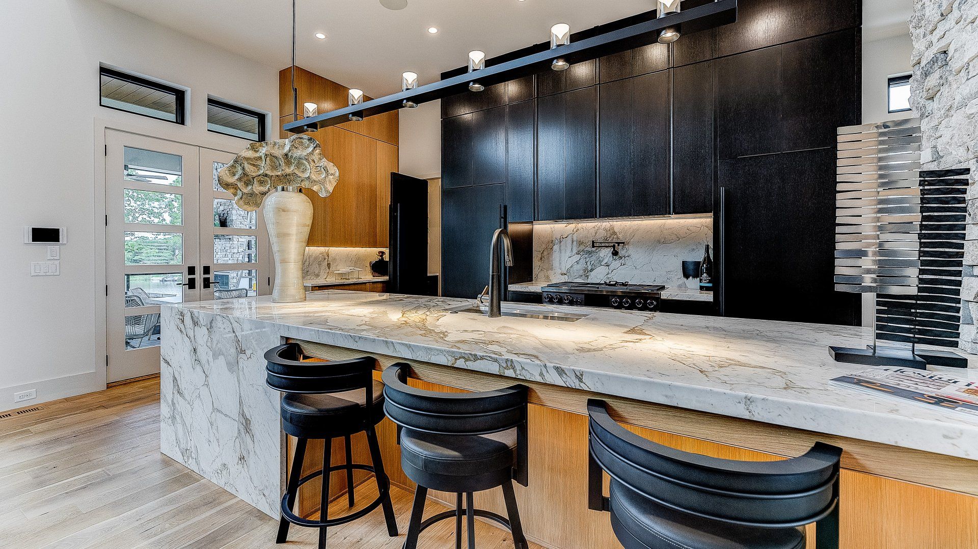 A kitchen with a large island and stools.