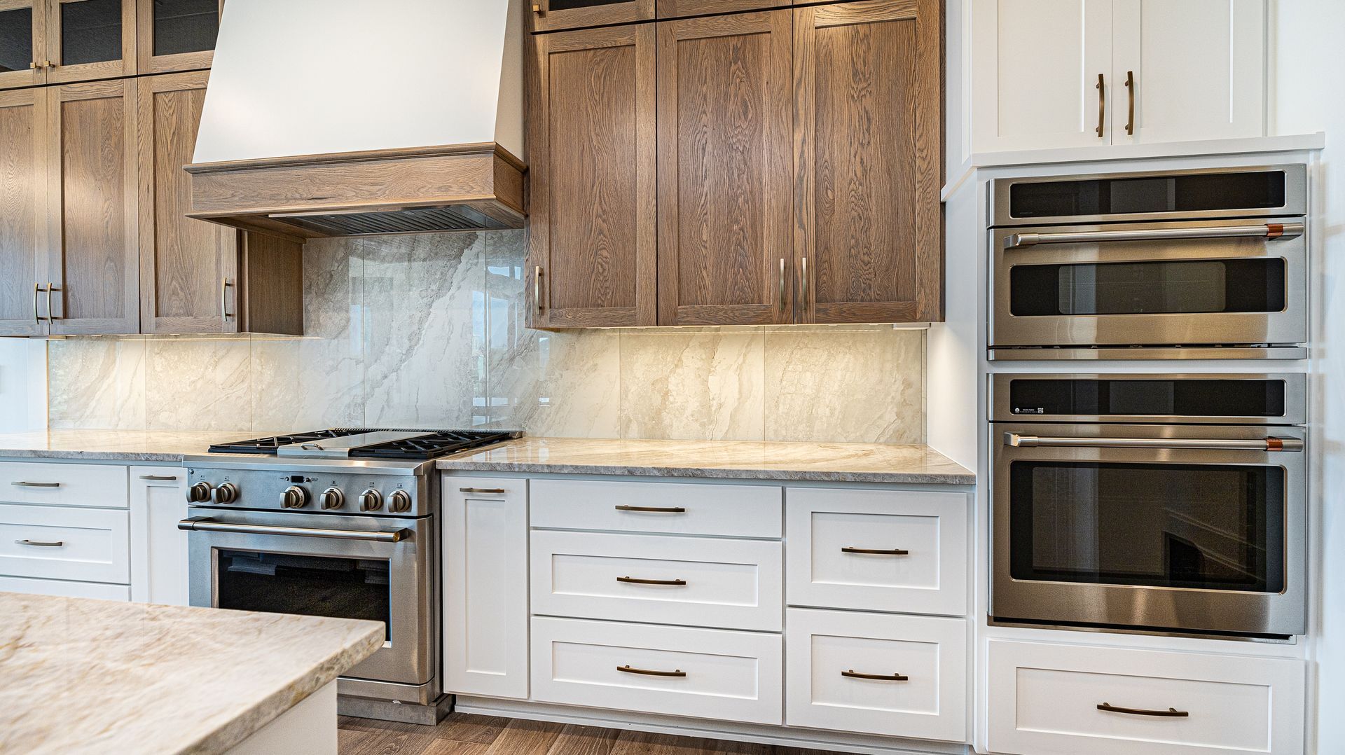 A kitchen with white cabinets , stainless steel appliances , and wooden cabinets.