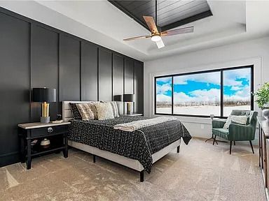 A bedroom with a bed , chair , nightstand and ceiling fan.