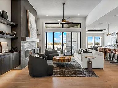 A living room with a couch , chairs , coffee table and fireplace.