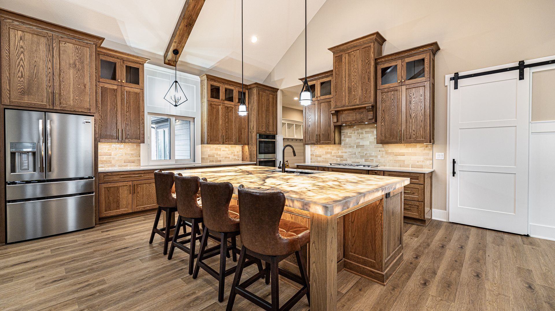 A kitchen with stainless steel appliances , wooden cabinets , and a large island.