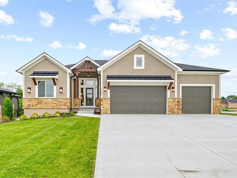 A large house with a concrete driveway and a large garage.