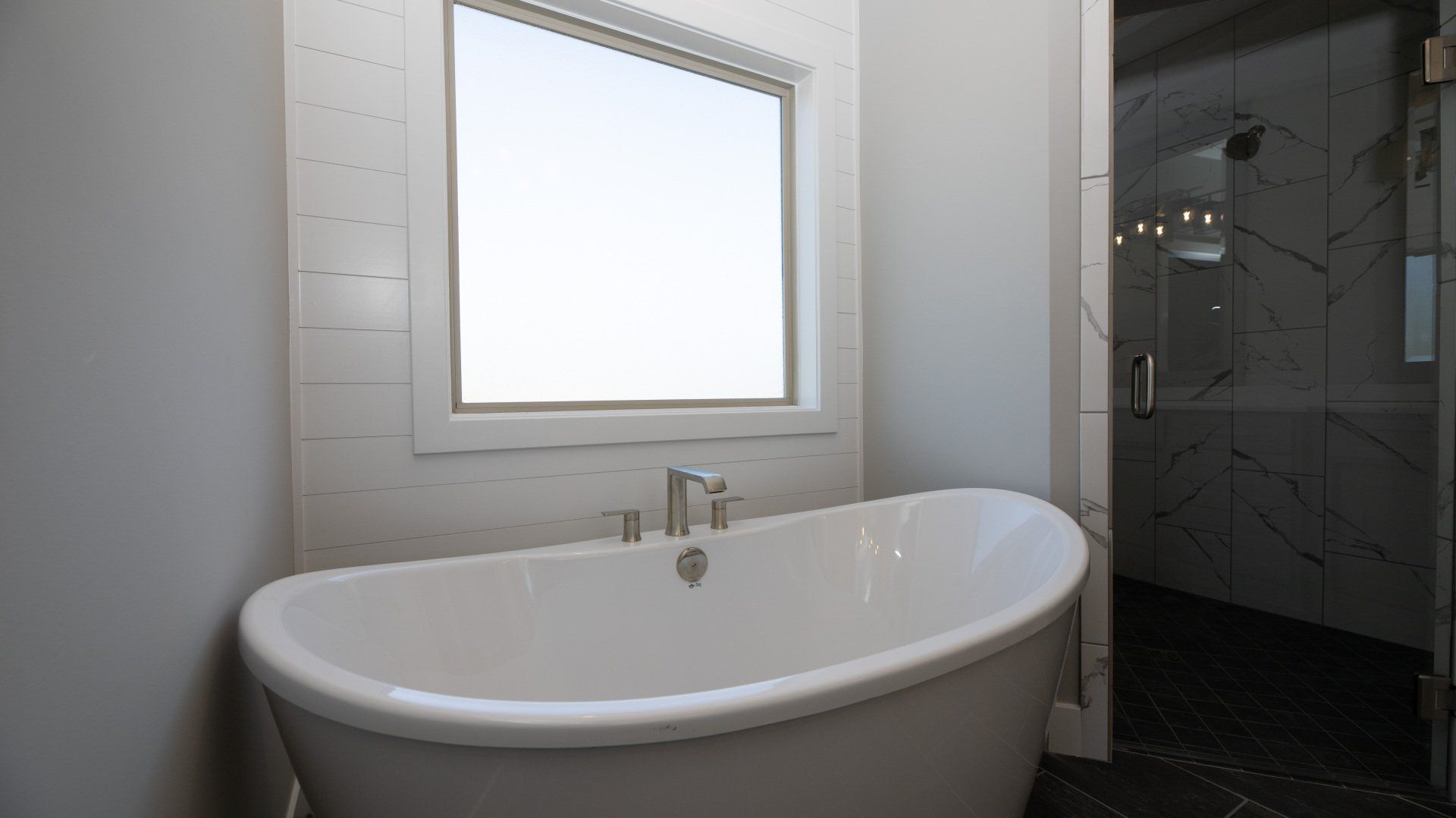 A bathroom with a bathtub and a window.