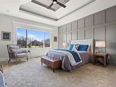 A bedroom with a bed , chair , nightstand , and ceiling fan.